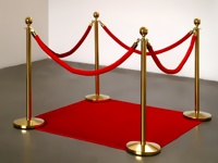 Стойки с золотым барьером соединены в круг на красной ковровой дорожке