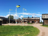 Trys vėliavos pakeltos ant stiebų šalia kaimo turizmo pastatų