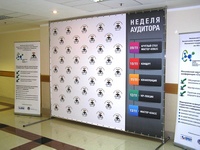 Renginio reklama ant sienos plakato, šonuose reklaminiai baneriai