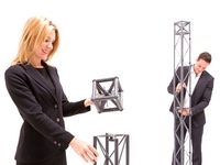 The woman holds the bench cube, the man constructs the beams